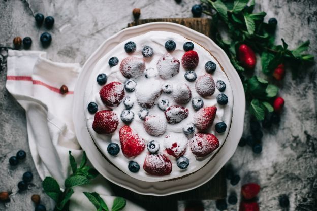 Torta a strati con crema golosa, fragole e mirtilli