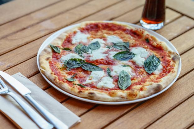 Pizza fatta in casa con  pomodorini freschi e basilico