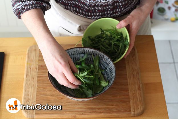 In una grande ciotola, mettere gli spinaci e la la rucola.